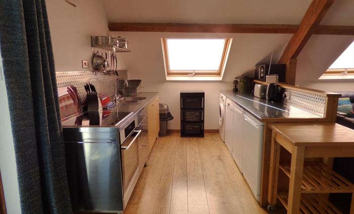 Sociable cooking in the open plan Tollant kitchen. This spacious barn conversion is a great place for getting together with friends.